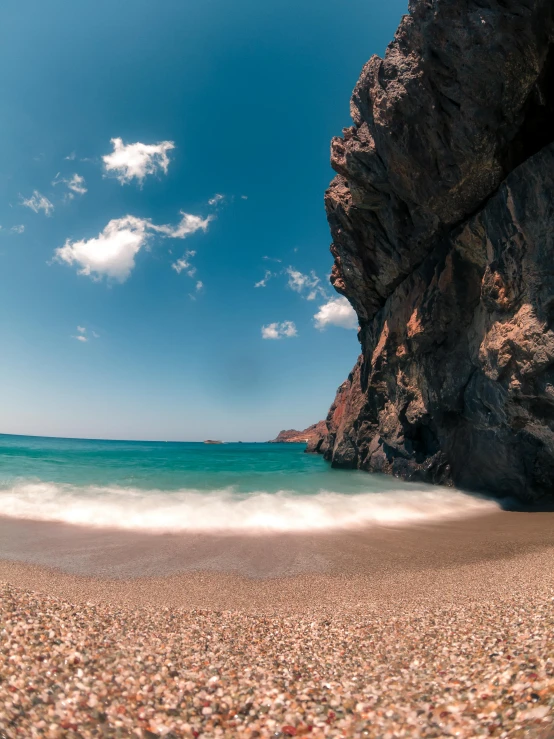 an ocean view from beach with rocks on the shore