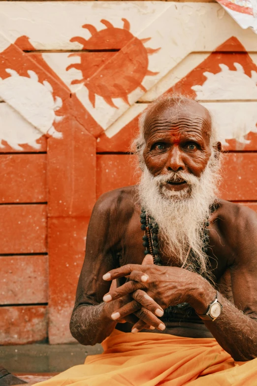 a man with a beard is sitting in front of a building