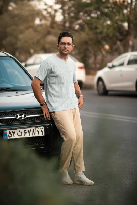 a man stands by a car with cars in the background