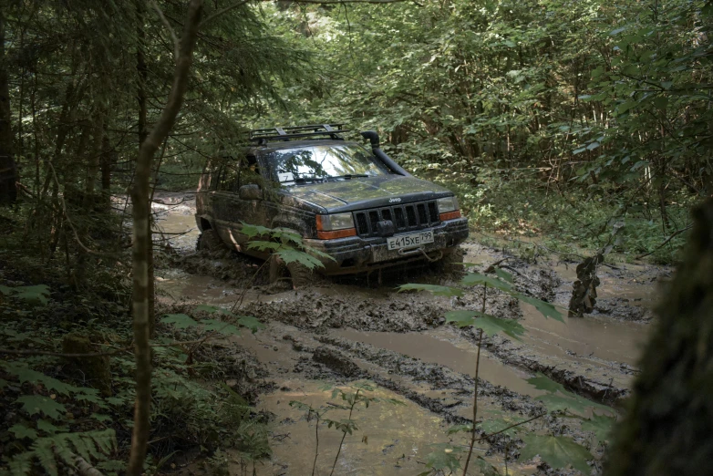 an suv with many different tires is on a muddy road