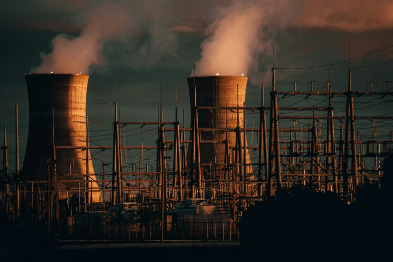 smoke billows out the stacks of factory chimneys