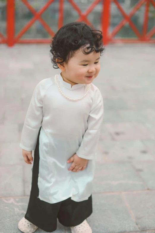 a little boy is dressed up in white and black