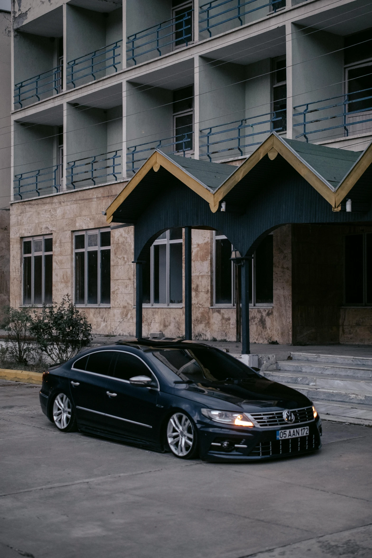 black sports car parked outside a el parking lot