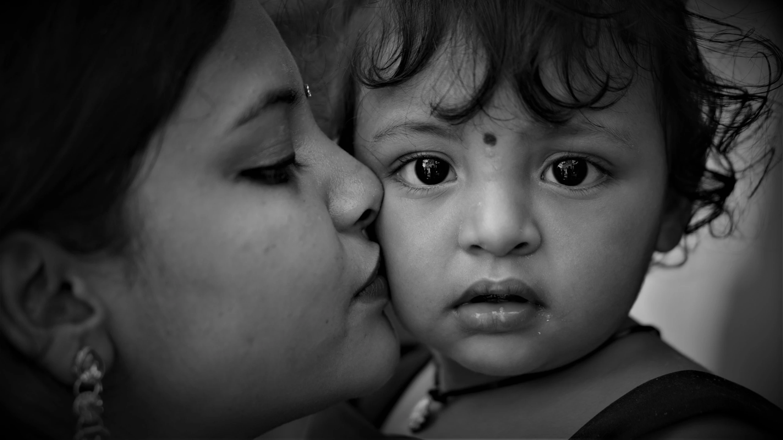 a woman and baby are kissing each other