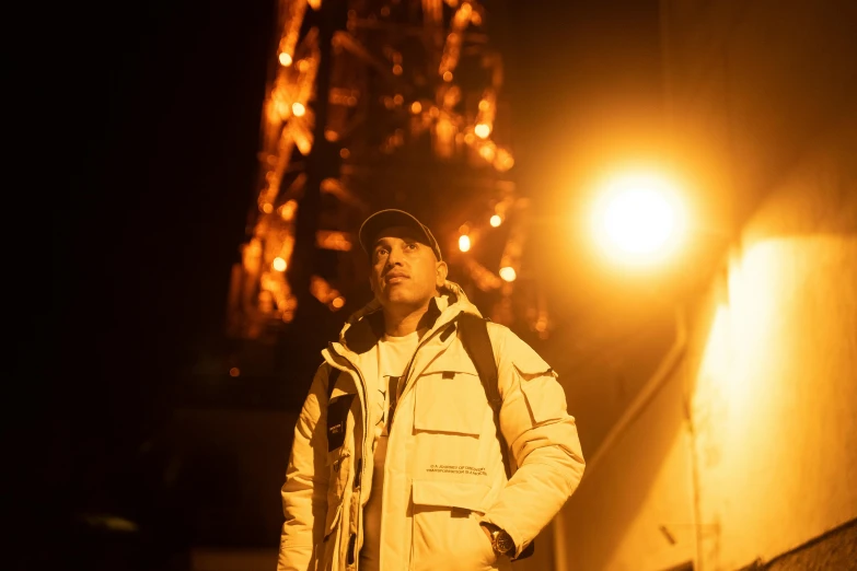 man standing by the eiffel tower at night