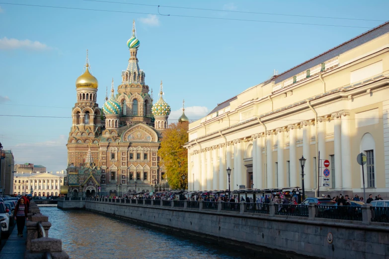 a river running alongside a building near some tall buildings