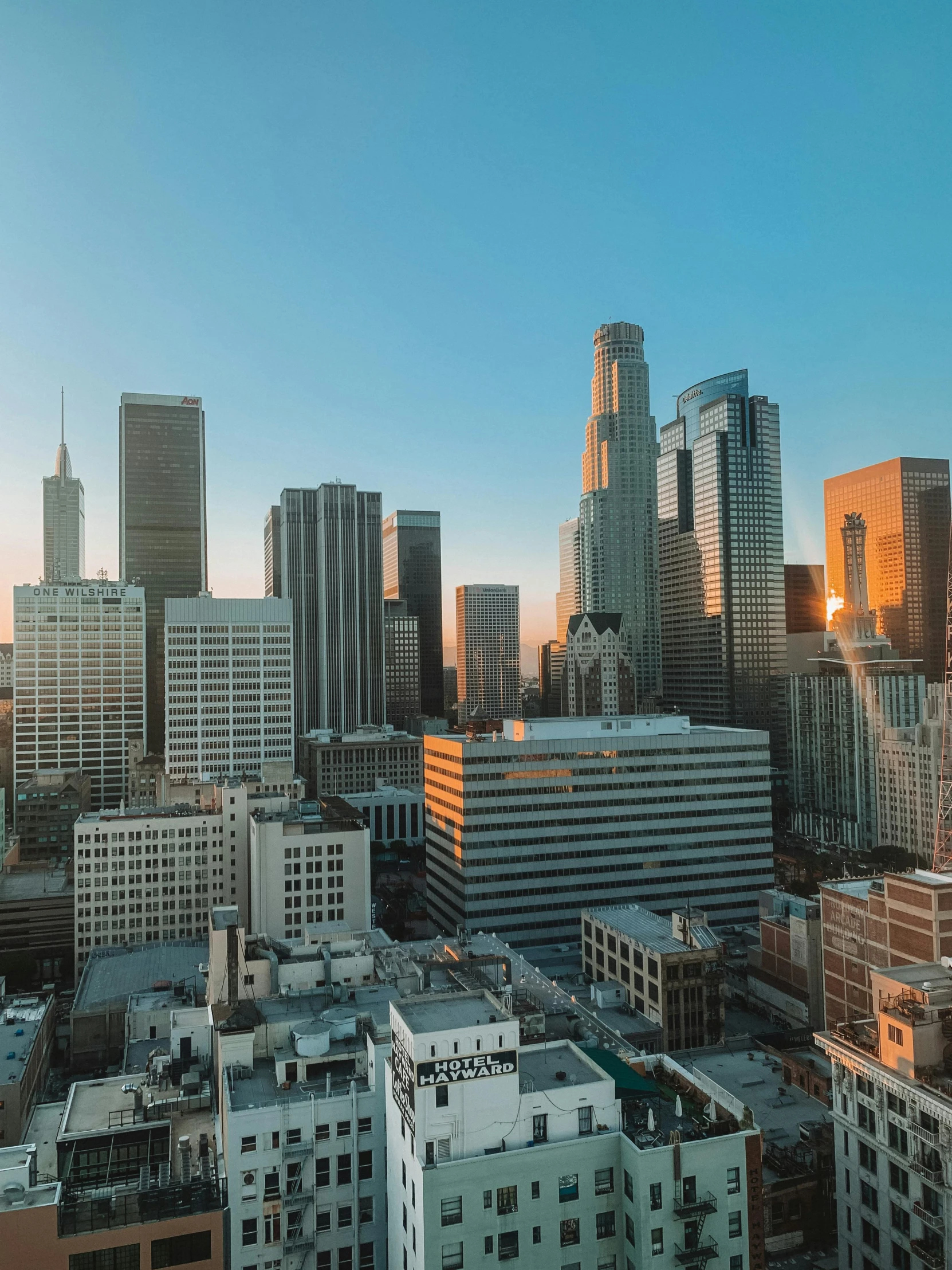 view of skyscrs in the skyline with the sun setting