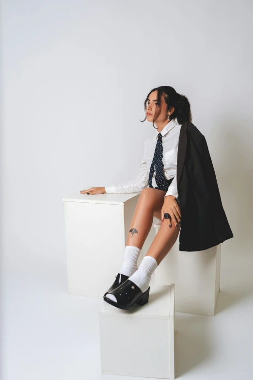 a woman wearing short shorts sitting on top of a white chair