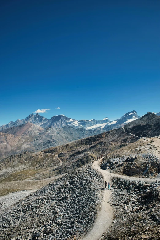 a person hiking up a rocky road in the mountains