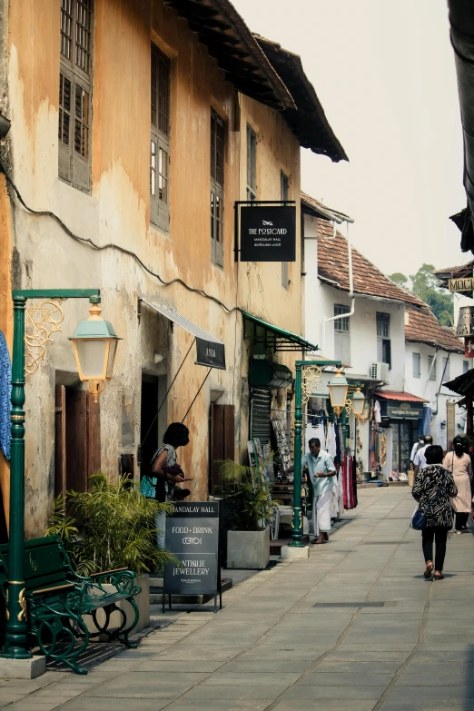 a street filled with tall buildings with people walking by them