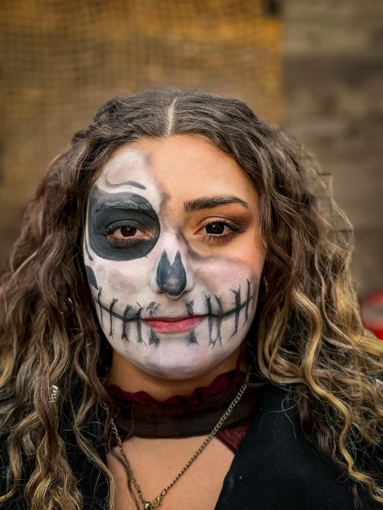 a woman with black makeup has a skull on her face