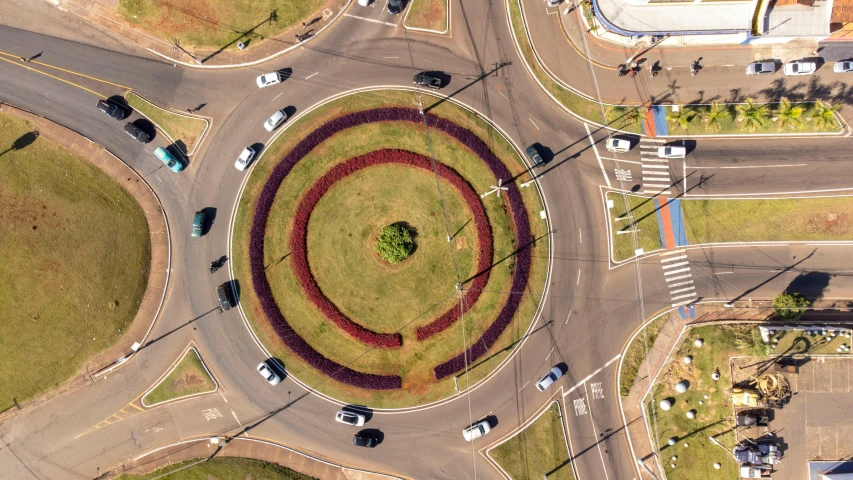 an overhead view shows the intersection of a roundabout with several cars in it