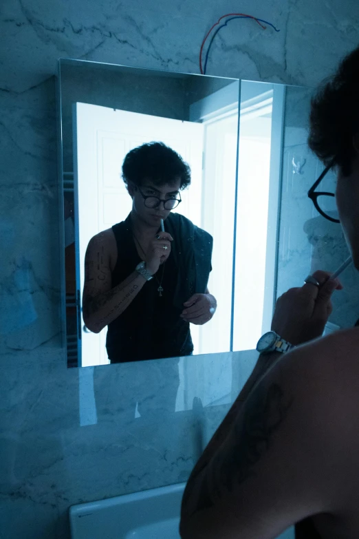 a person standing in front of a mirror while shaving