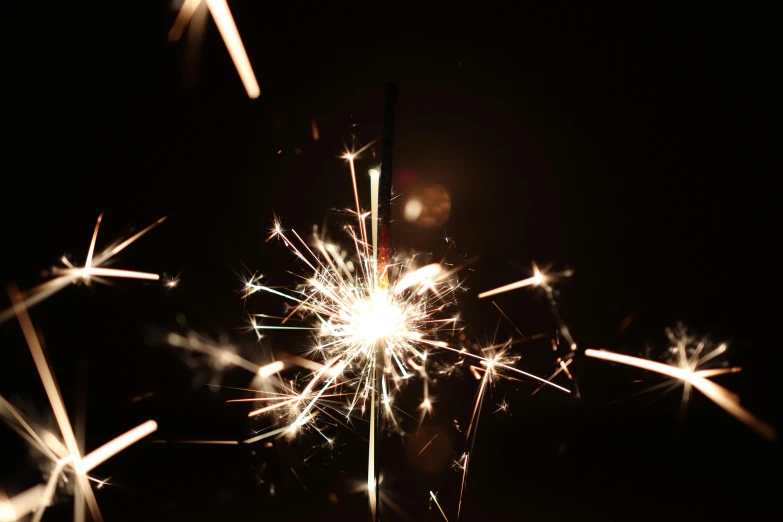 a sparkler exploding with lots of lights on a black background