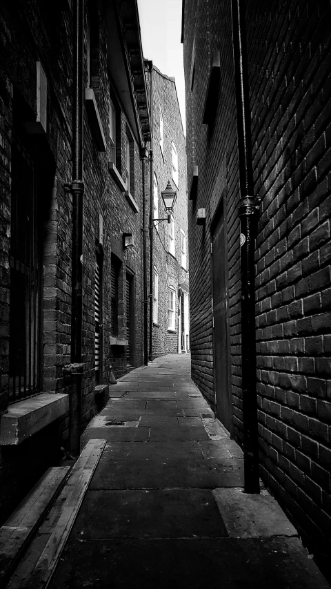 an alley with stone buildings and a street light