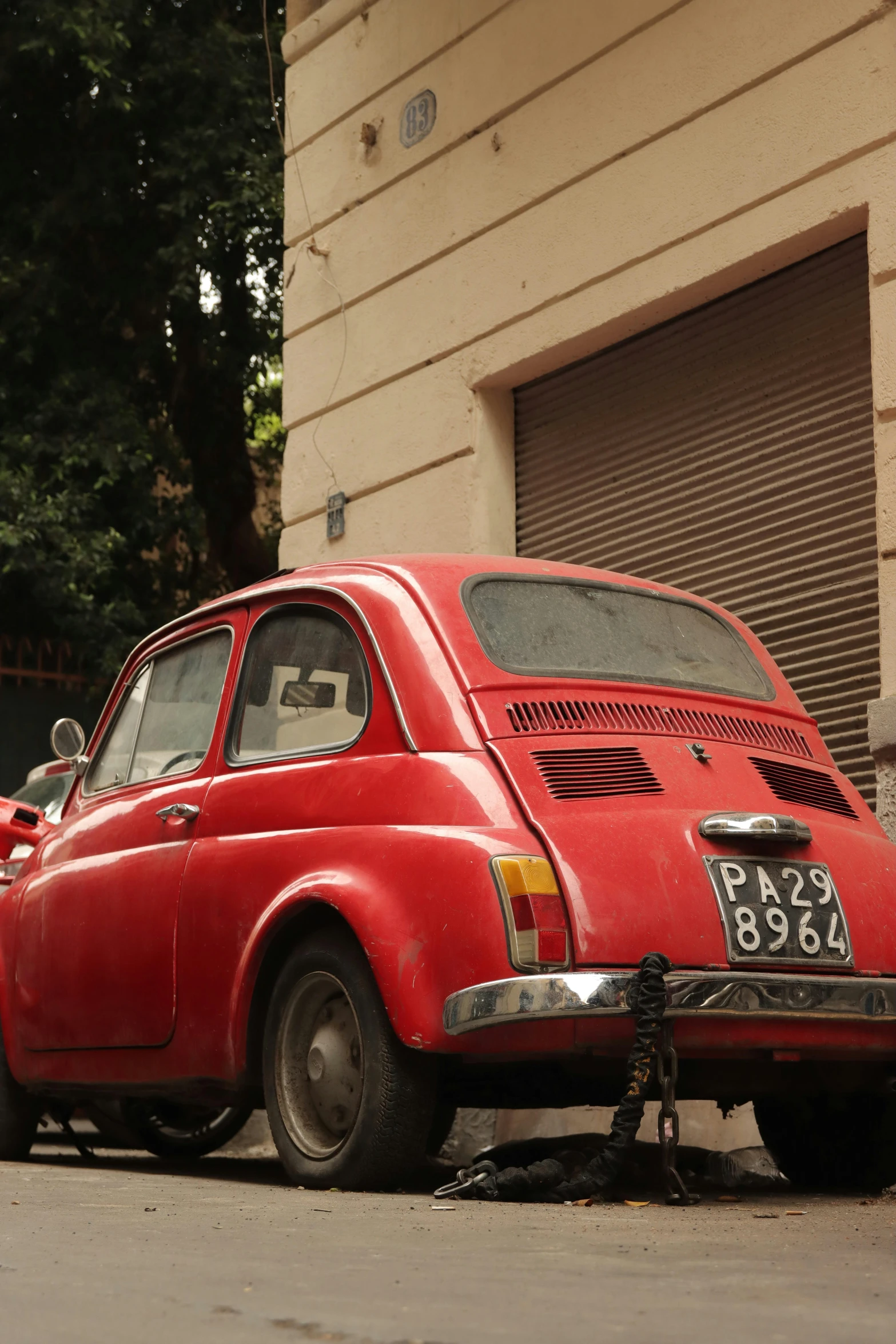 an old fashioned red car is parked outside a building