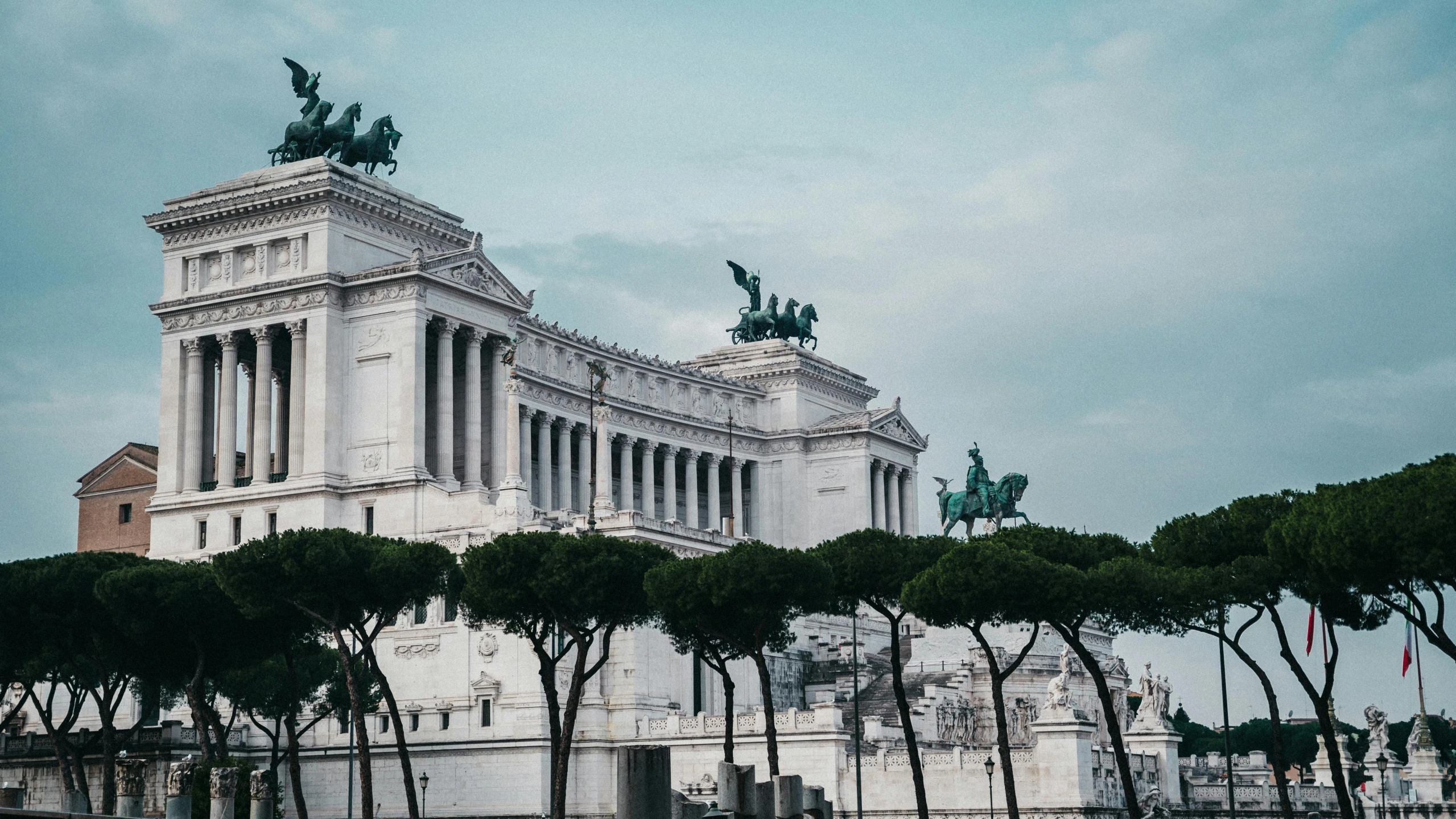 the monument and trees in front of a white building