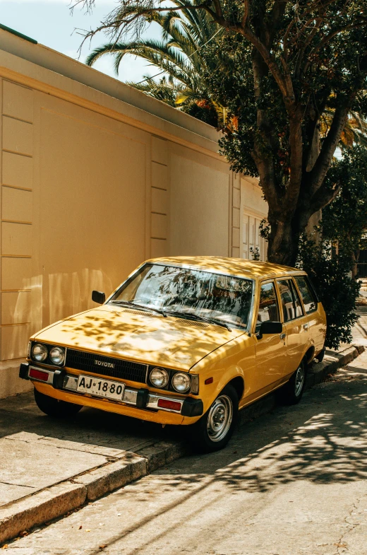 an old yellow car parked on a city street