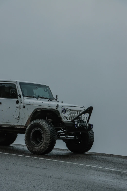 a hummer truck is covered in snow on the side of the road
