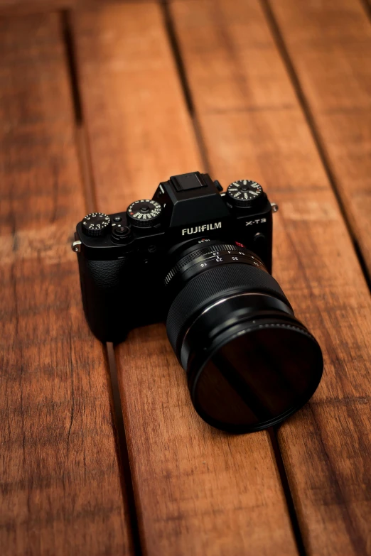 a camera on top of a wooden table next to a wall