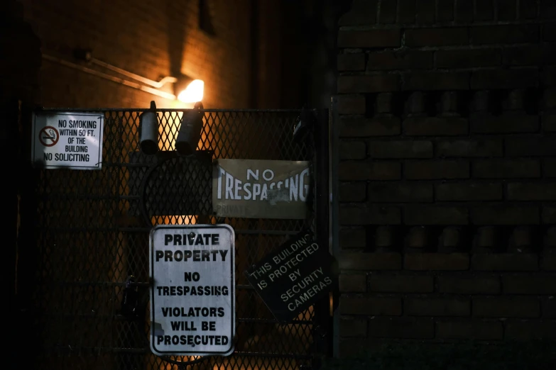 a building is lit by street lights, signs and a fence