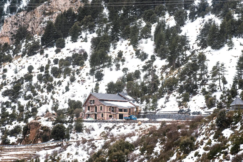 a mountain covered in snow with a large house on the side