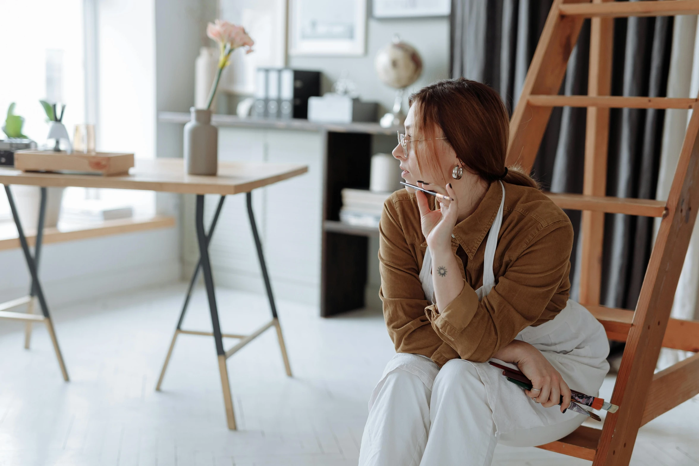 a woman sits on a ladder in her house