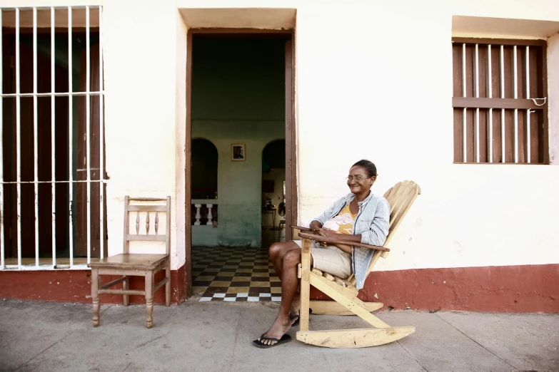 a person sitting on a rocking chair outside