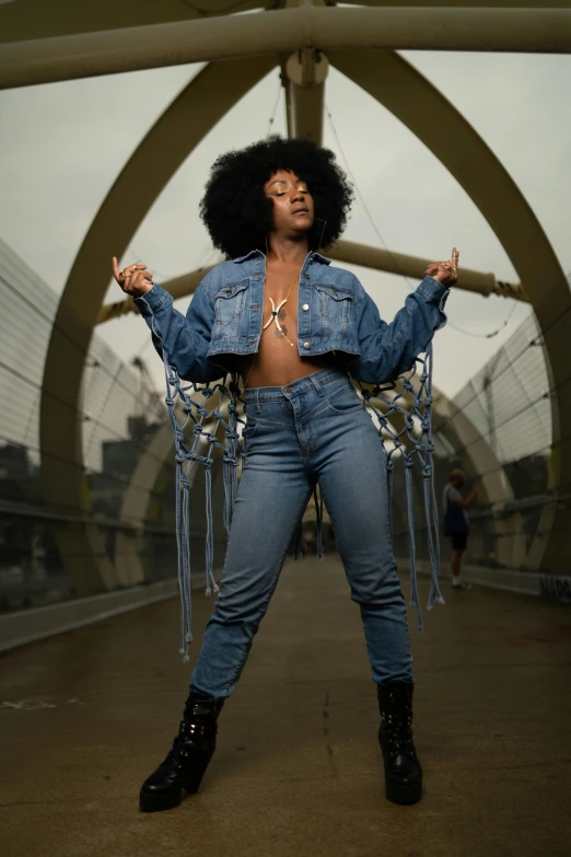 a woman dressed in jeans and a jean jacket standing outside