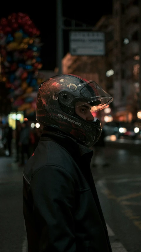 person wearing a helmet and standing next to the street