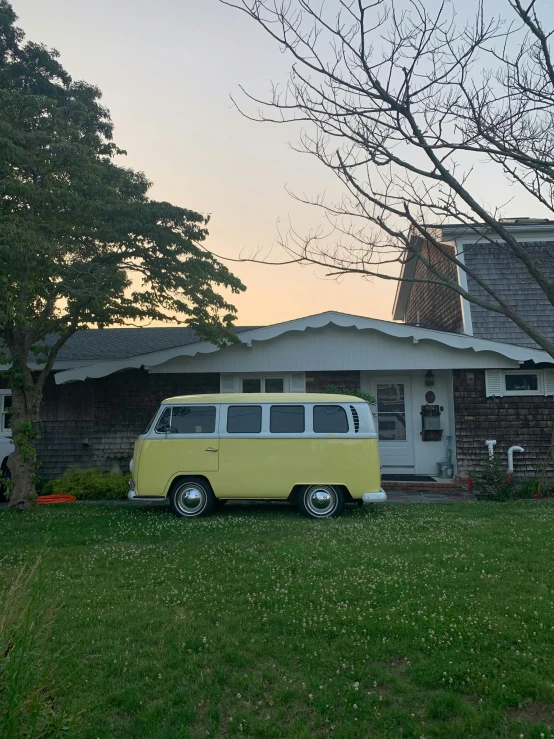 a small yellow and white van parked in front of a house