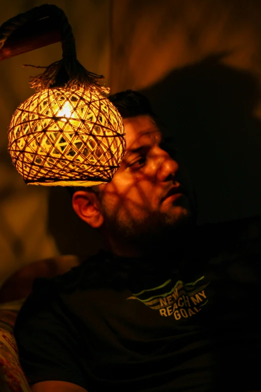 a person sits down while looking at the light of a lamp