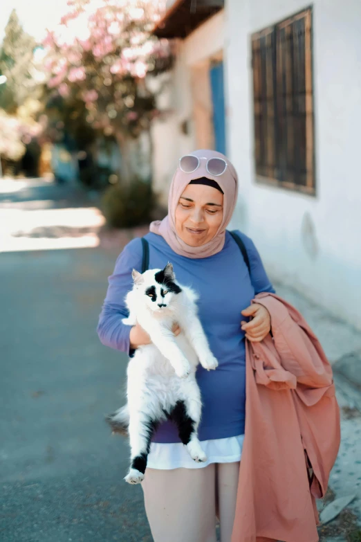 a woman is walking down the street with her cat