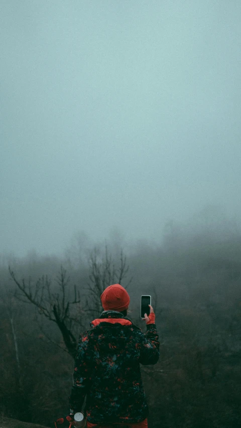 a person is standing with a phone up to their ears