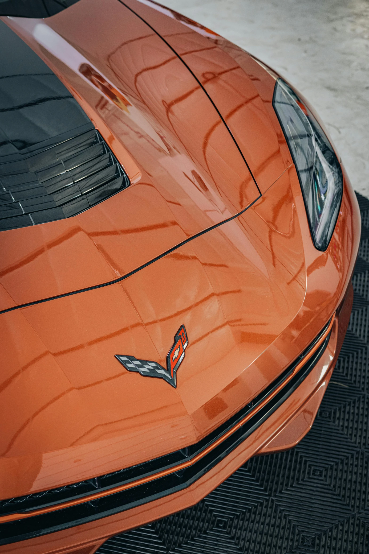 close up of the front fender and badge on a orange corvette