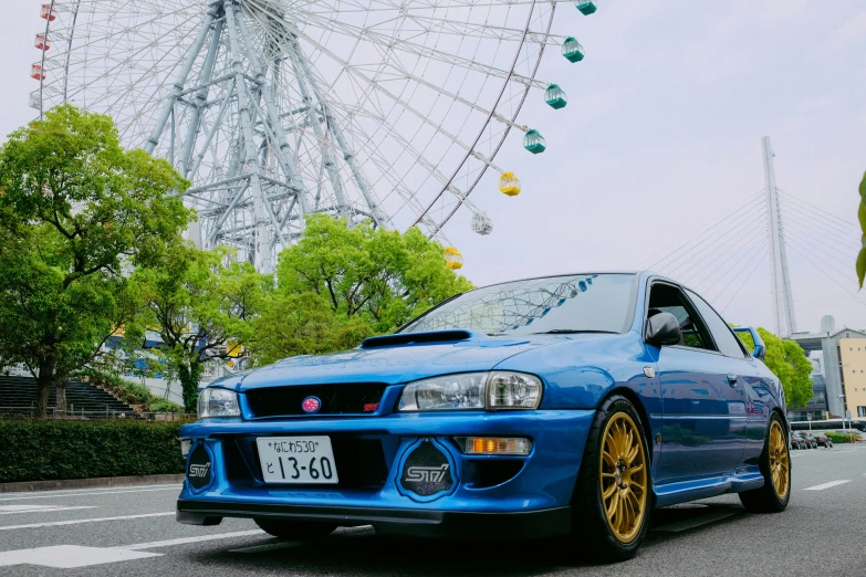 an engine blue subarunt sits parked on the side of the road