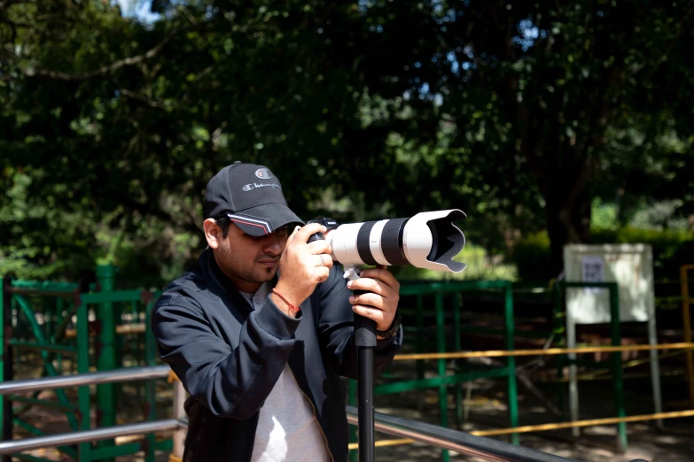 man in black jacket taking a pograph on his camera