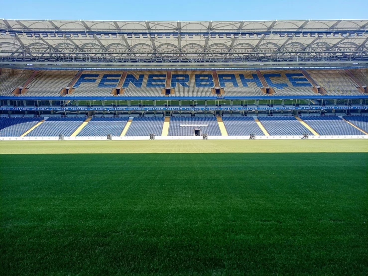 a field with a blue stadium filled with lots of bleachers