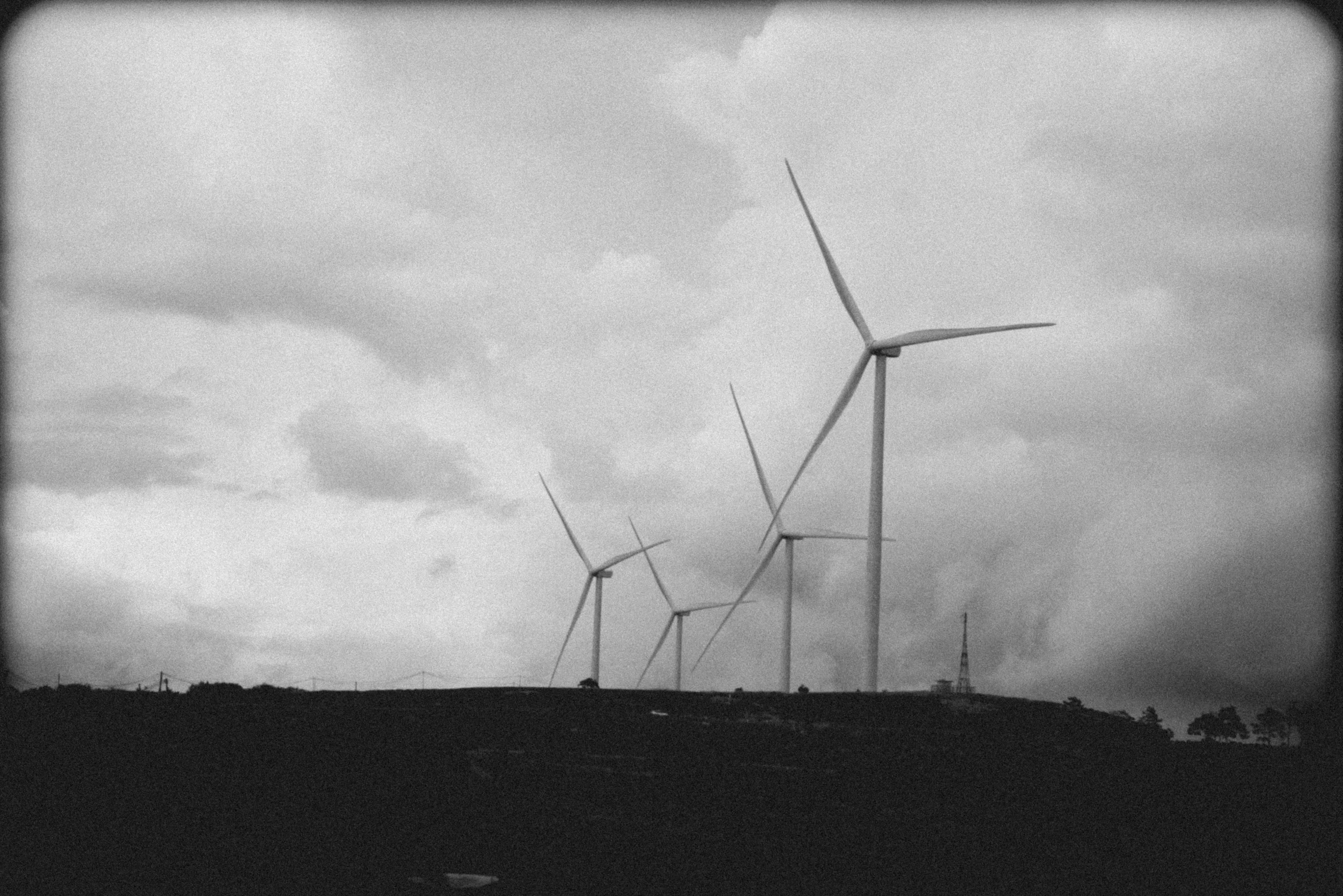 some wind turbines on a dark cloudy day