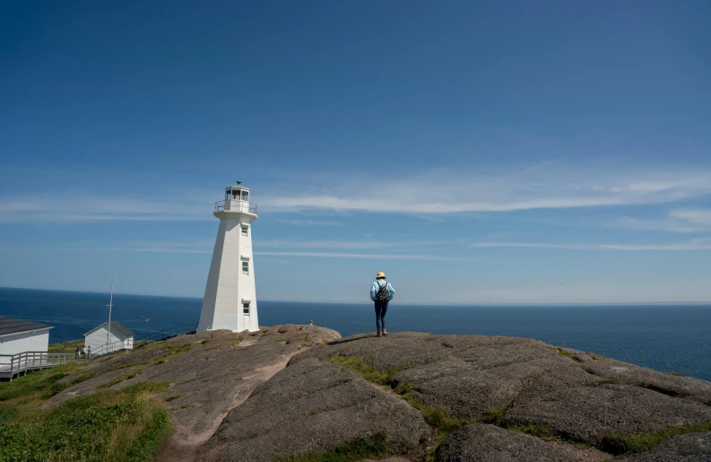 a person standing on top of a hill near the ocean