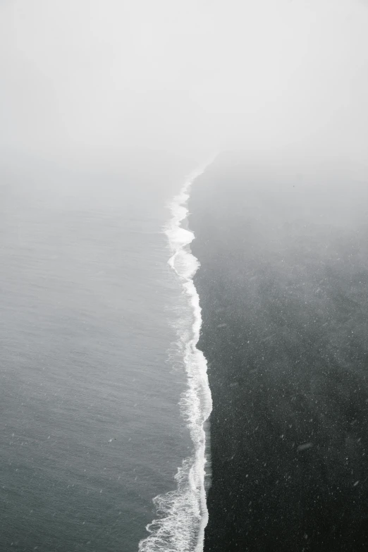 a long line of water with waves rolling up to it's shore