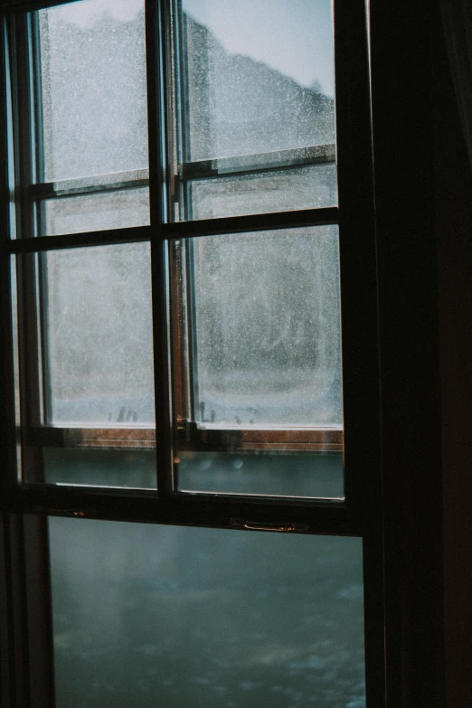 open window showing snow and mountain outside in dark room