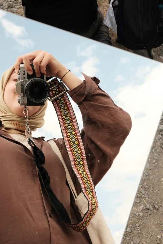 a woman holding a camera and looking up in the sky