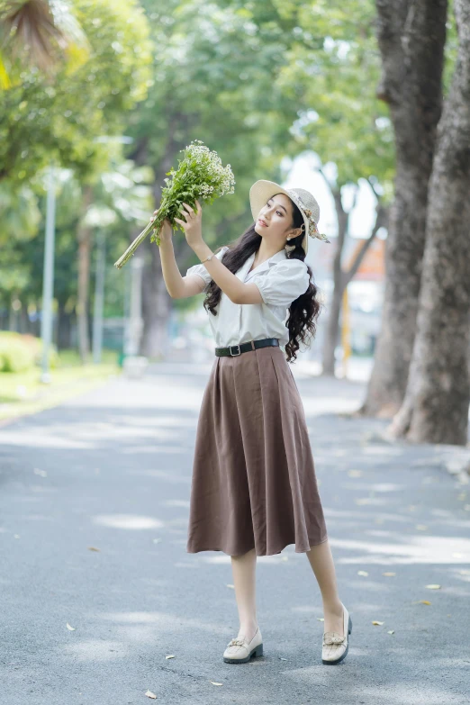 an asian woman in a brown skirt holding flowers