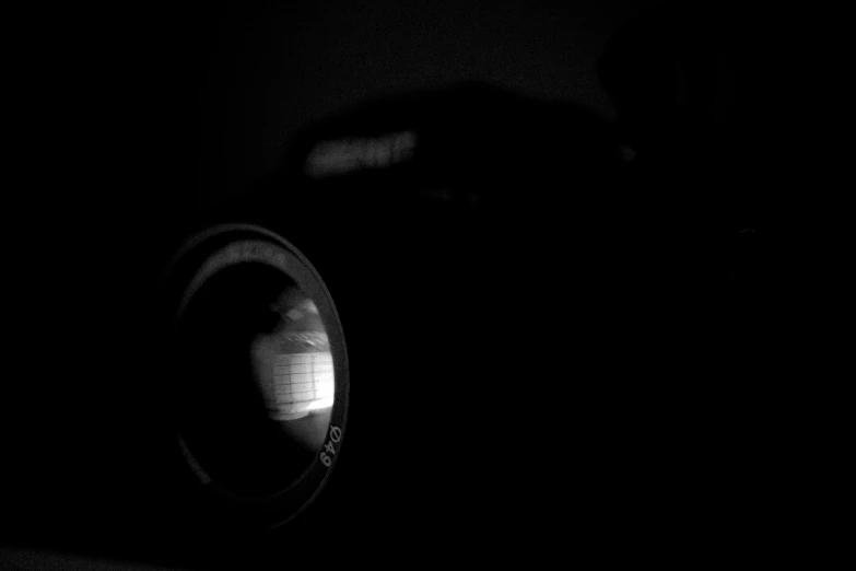 black and white pograph of someone looking through a lens