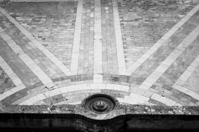 the corner of a building with a small brick window and an iron water pump