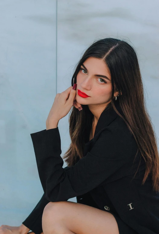 a woman in a black suit sitting down