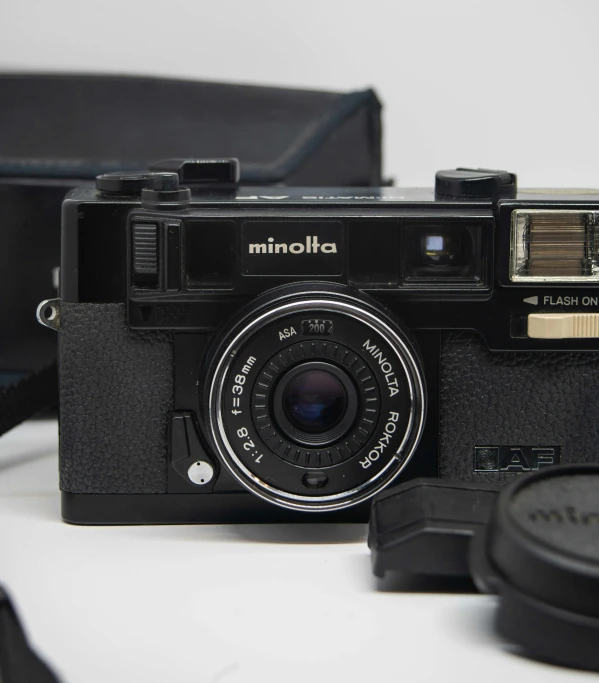 an old camera sitting next to a black bag