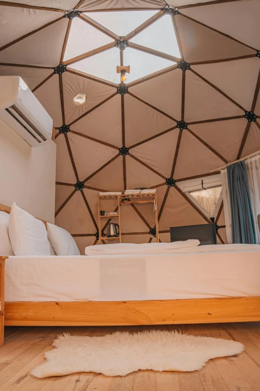 the interior of a yurt tent with white bedding and tan walls