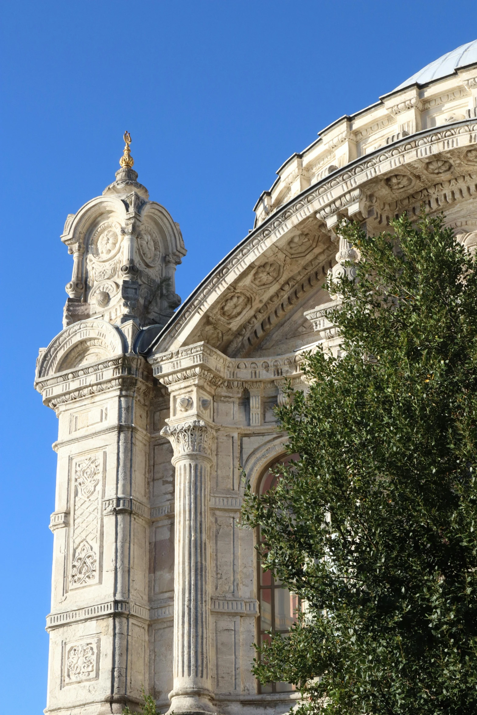 an ancient building against a blue sky with a large stone clock tower